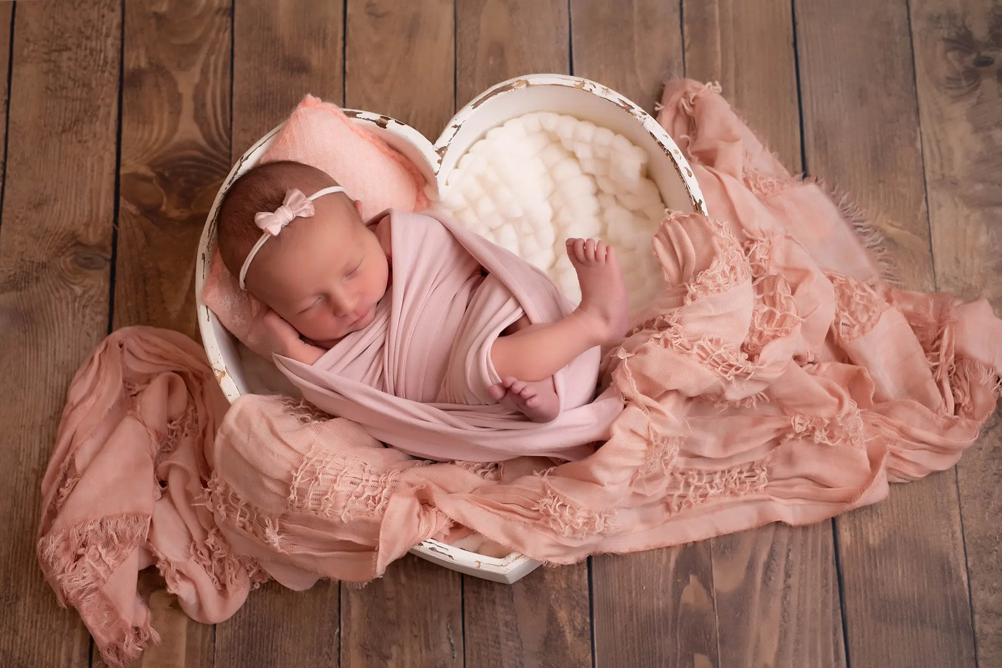 Photographe naissance Le Mans - Bébé emmailloté dans un panier coeur
